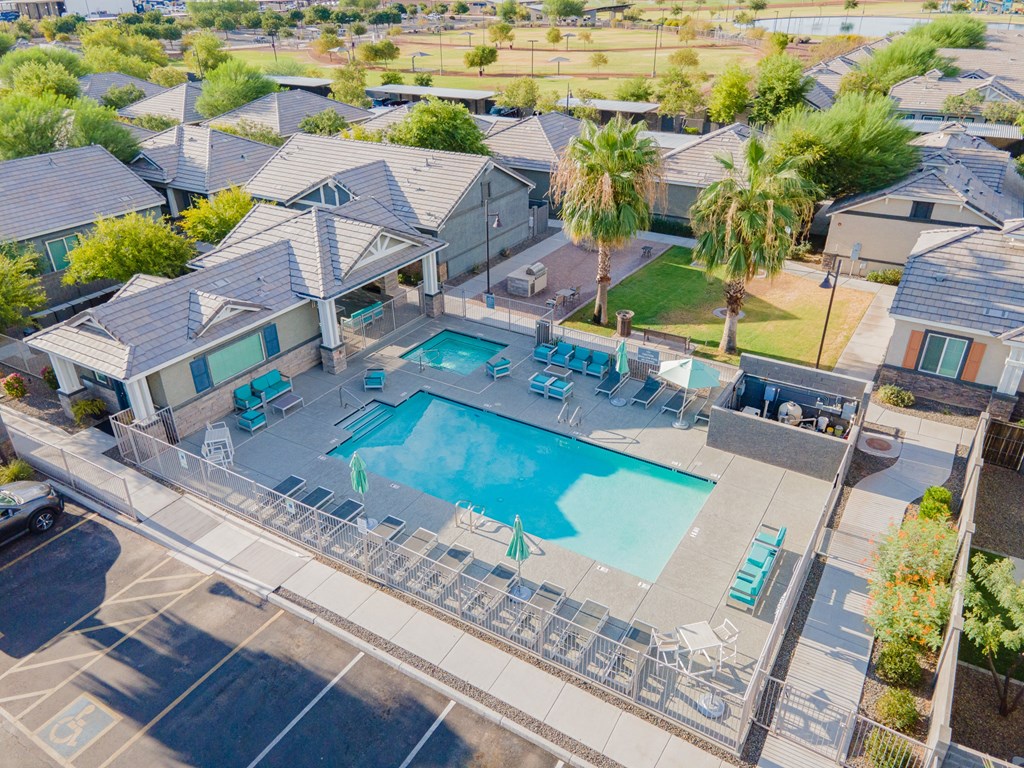 an aerial view of a swimming pool and a house with a pool and chairs