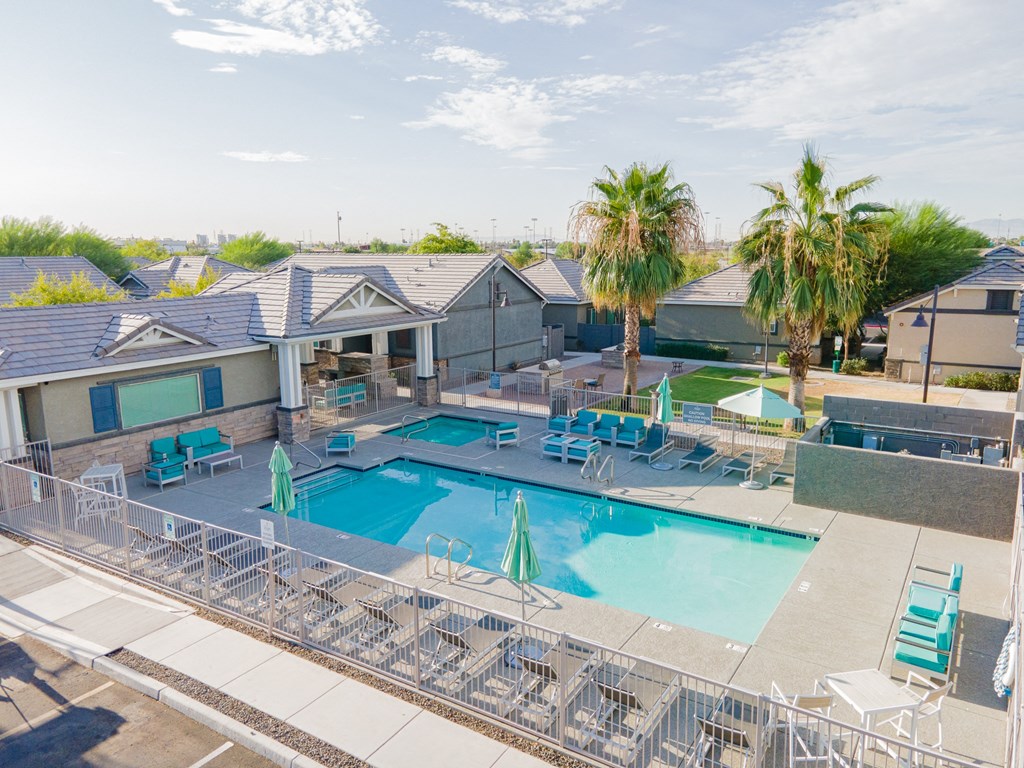 our apartments have a swimming pool with chairs and palm trees
