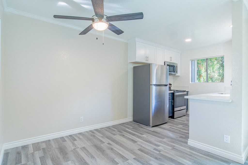 A kitchen with a refrigerator, microwave, and oven.