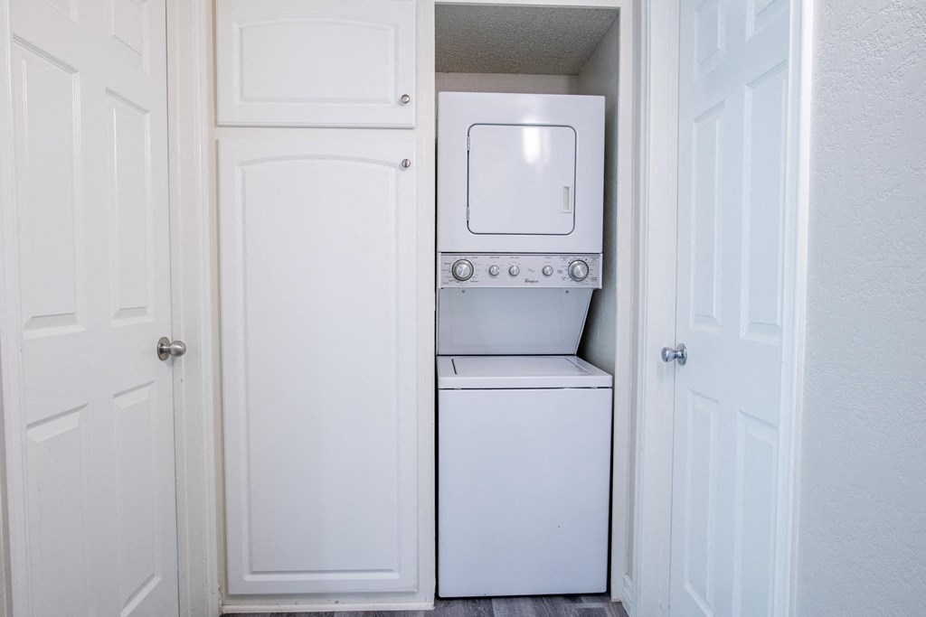 A white washing machine is in a small laundry room.