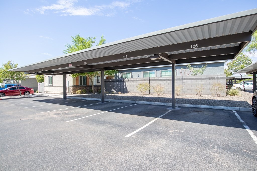 an empty parking lot with a canopy in front of a building