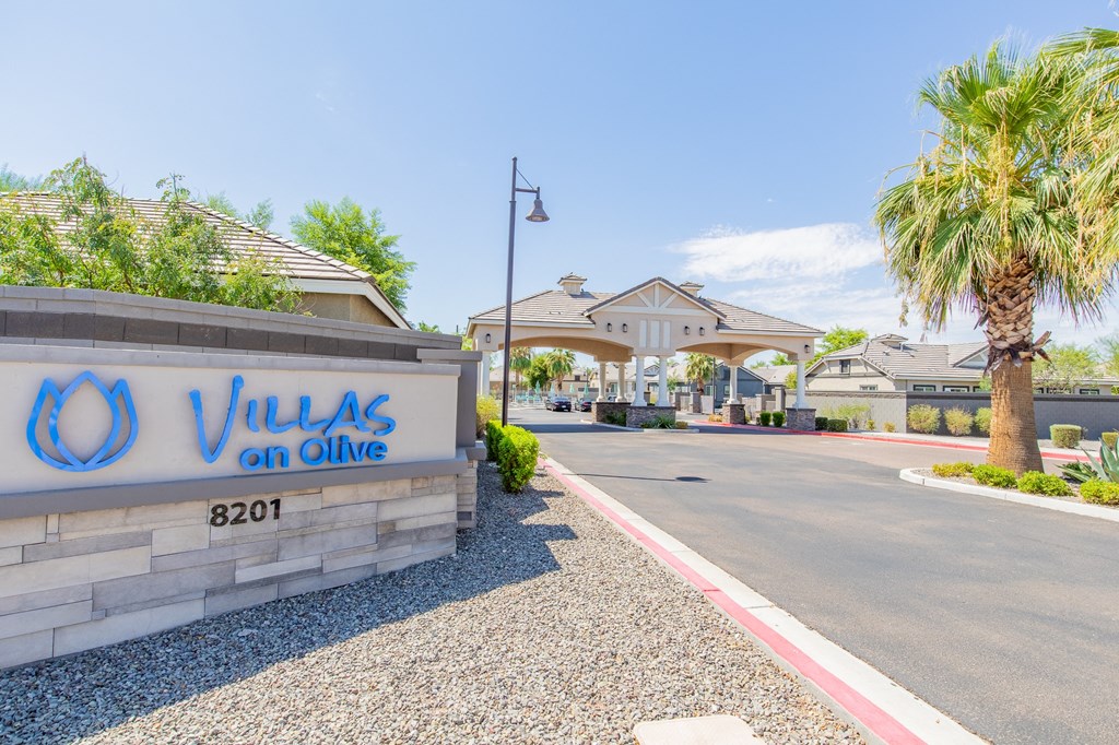a villas on olive apartments entrance with a sign and palm trees
