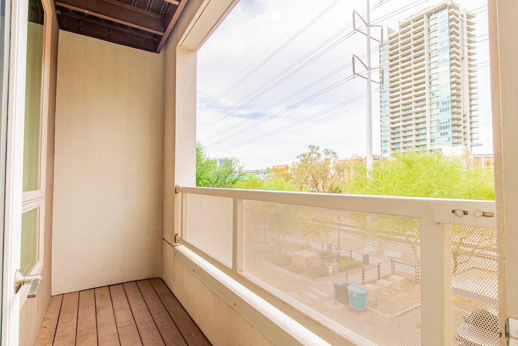 a balcony with a large window and a view of a building