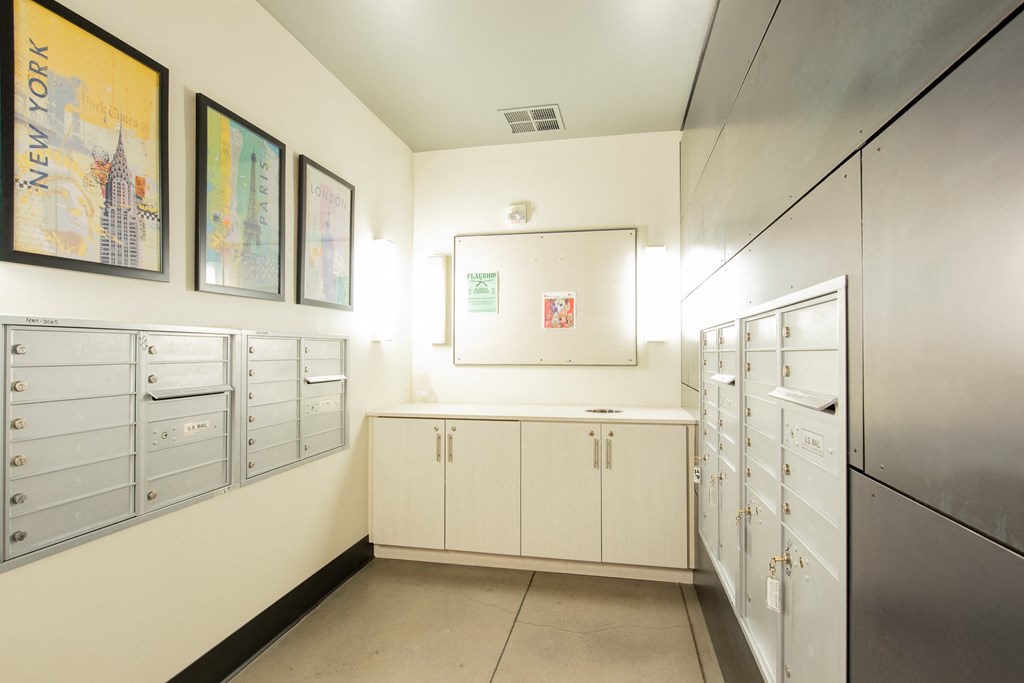 a utility room with white cabinets and drawers and pictures on the wall