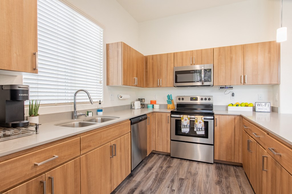 a kitchen with wooden cabinets and stainless steel appliances and a sink