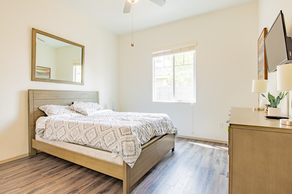 a bedroom with a bed and a dresser and a window