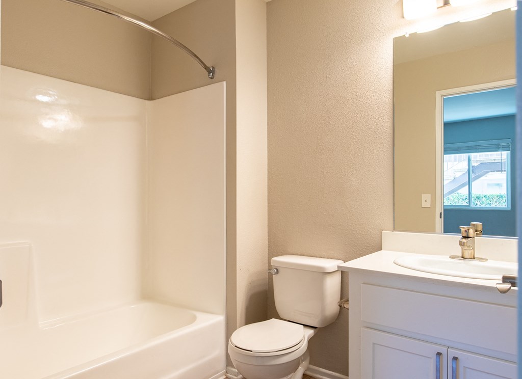 a bathroom with a toilet and a tub and a sink