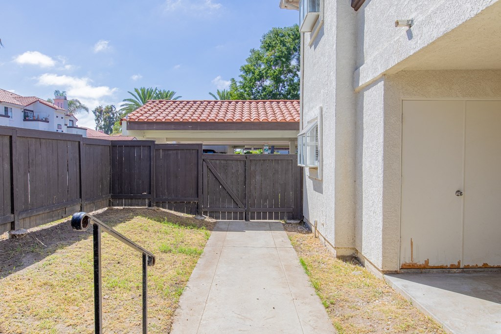 the entrance to a fenced in yard of a house