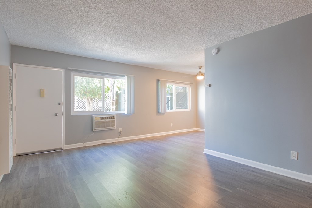 an empty living room with white walls and a window