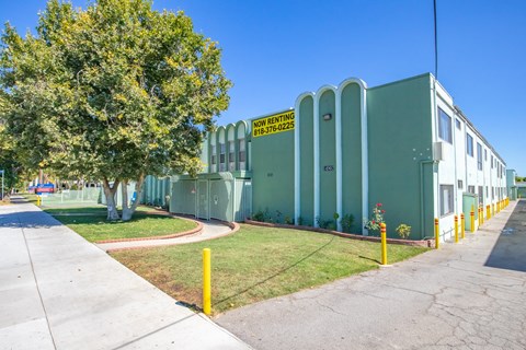 A green building with a yellow sign that says "NO RENTING" on it.