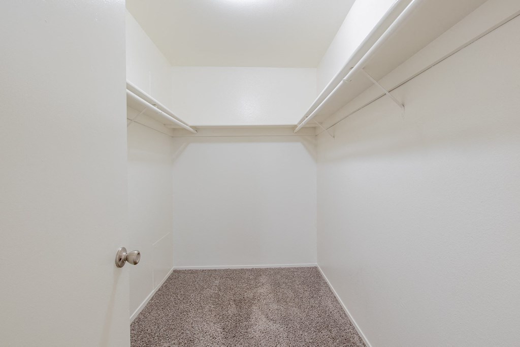 a empty room with white walls and carpet and a door
