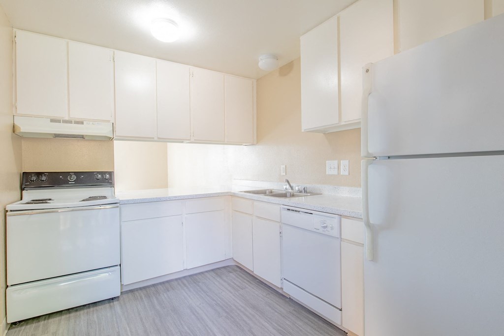 a white kitchen with white appliances and white cabinets