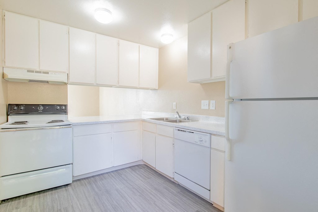a white kitchen with white appliances and white cabinets