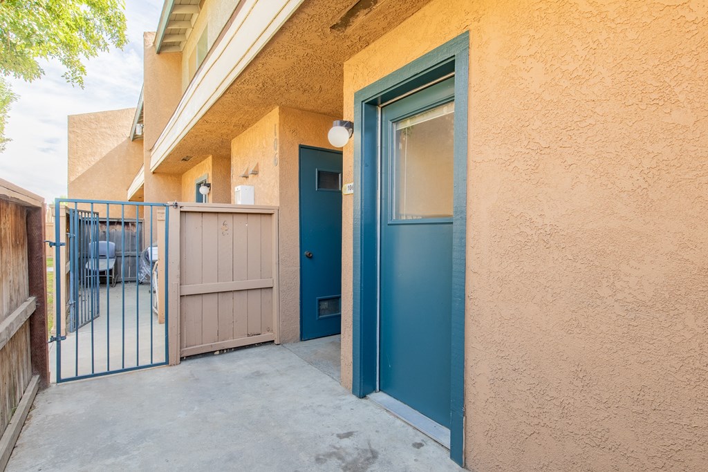 the entrance to a building with a blue door and a gate