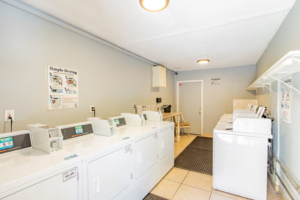 a laundry room with washers and dryers and a door to a room with