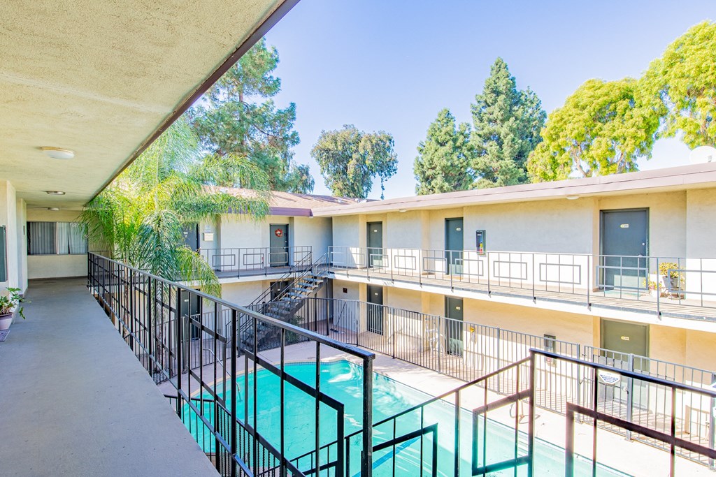 a balcony with a pool and a building with trees