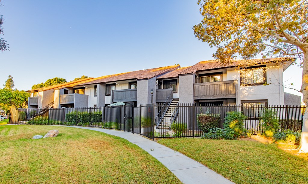 an apartment building with a sidewalk in front of it