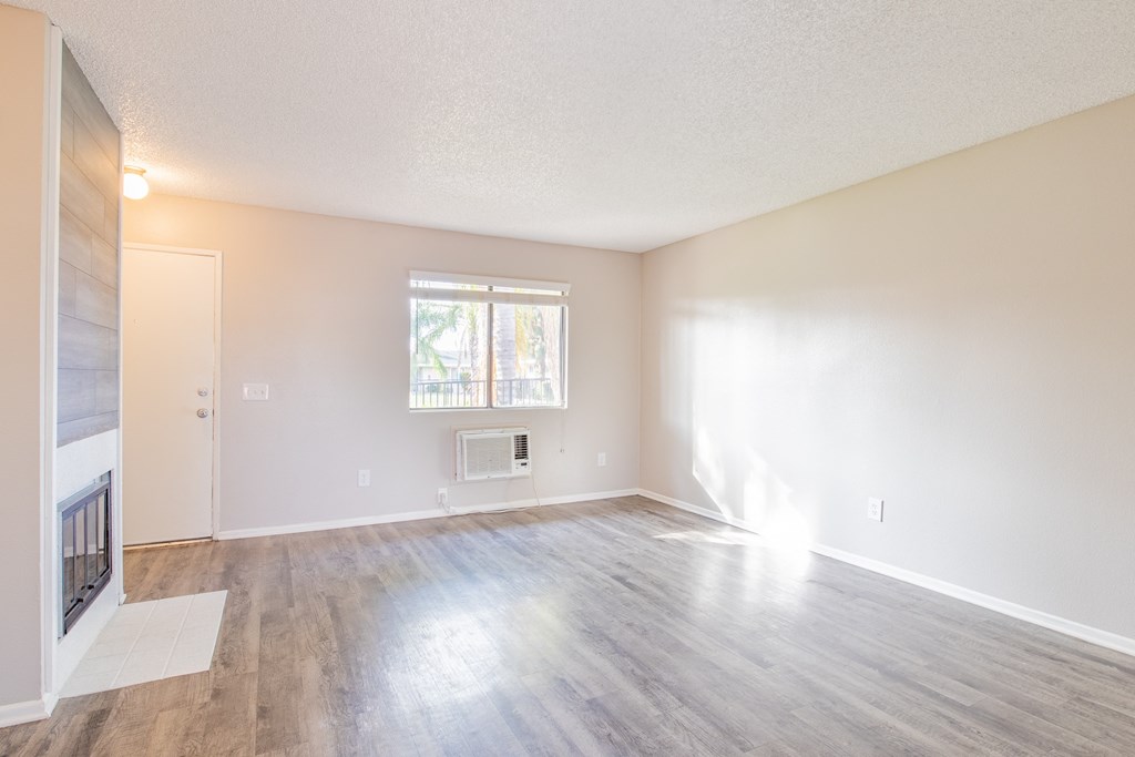 an empty living room with a fireplace and a window