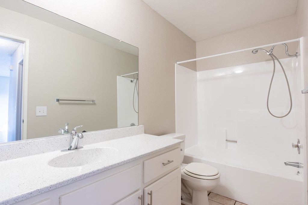 a bathroom with a large mirror and a toilet and a sink