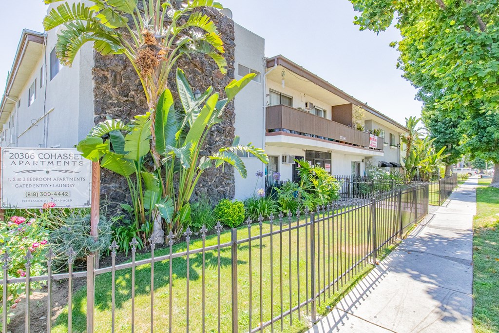 a house with a yard and a fence in front of it
