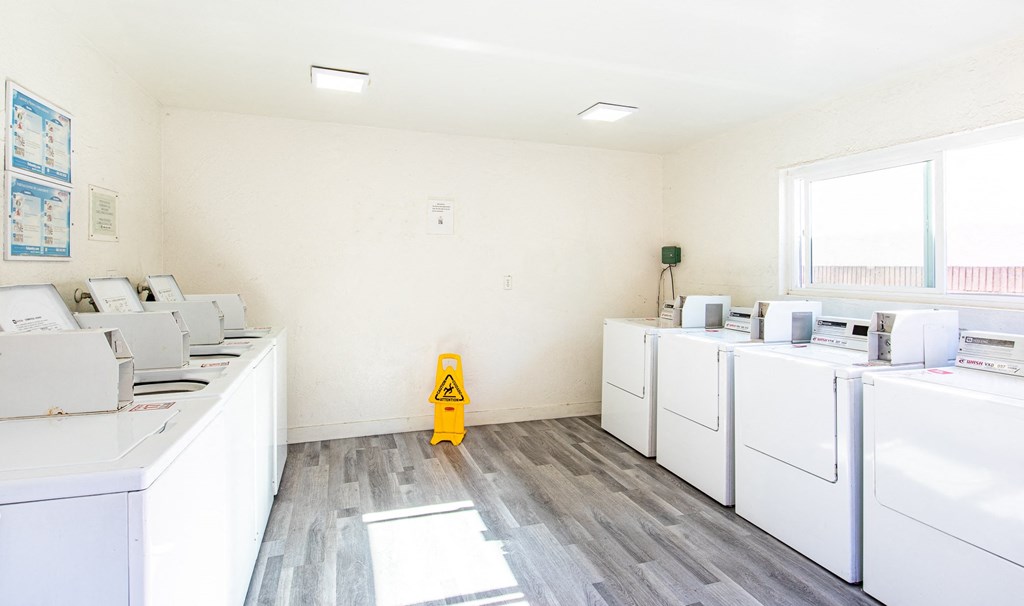 a room filled with washers and dryers and a yellow fire hydrant