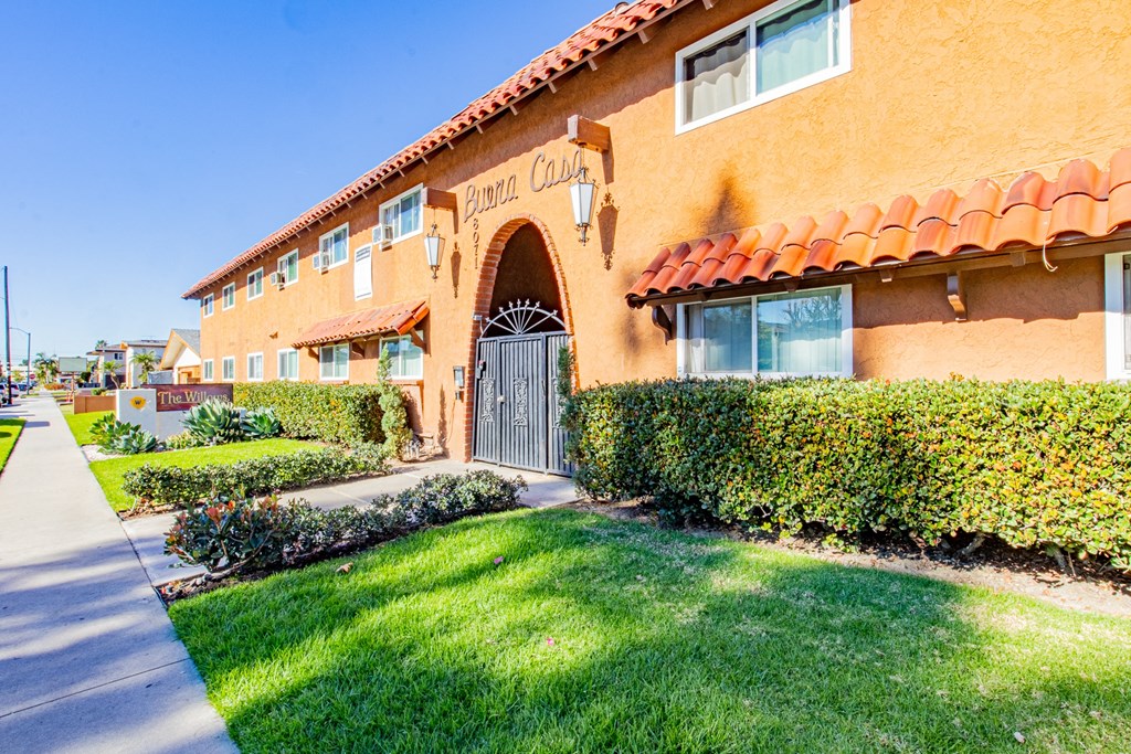 A building with a red tile roof and a sign that says "Pomona College" on it.