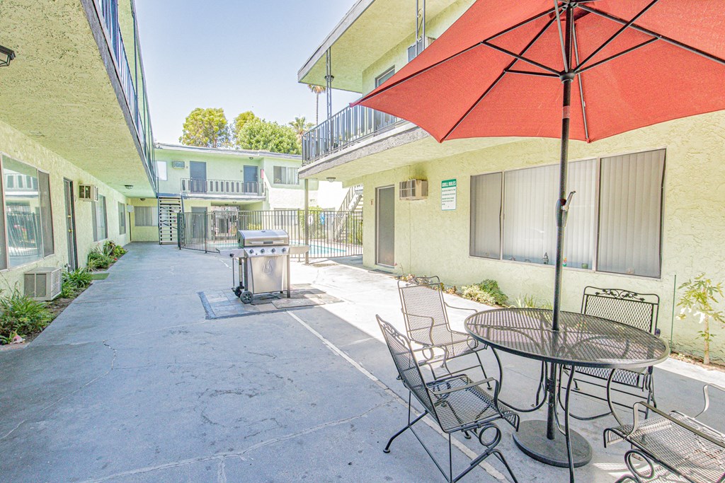 a patio with a table and chairs and an umbrella