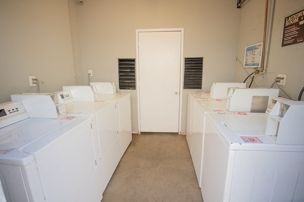 a row of washing machines in a room with a door