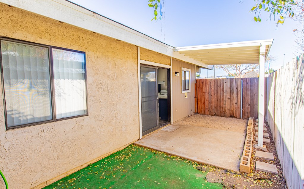 the front yard of a house with a patio and a backdoor to a yard