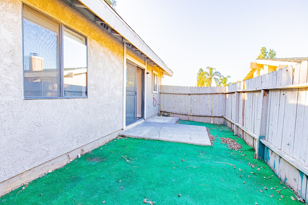 the backyard of a house with a green yard and a fence