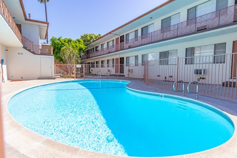 A blue swimming pool in front of a building.