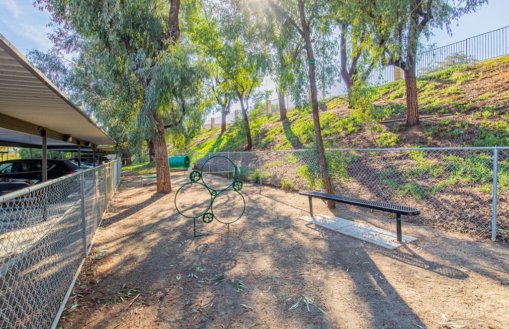 a picnic area with a bench and a chain link fence