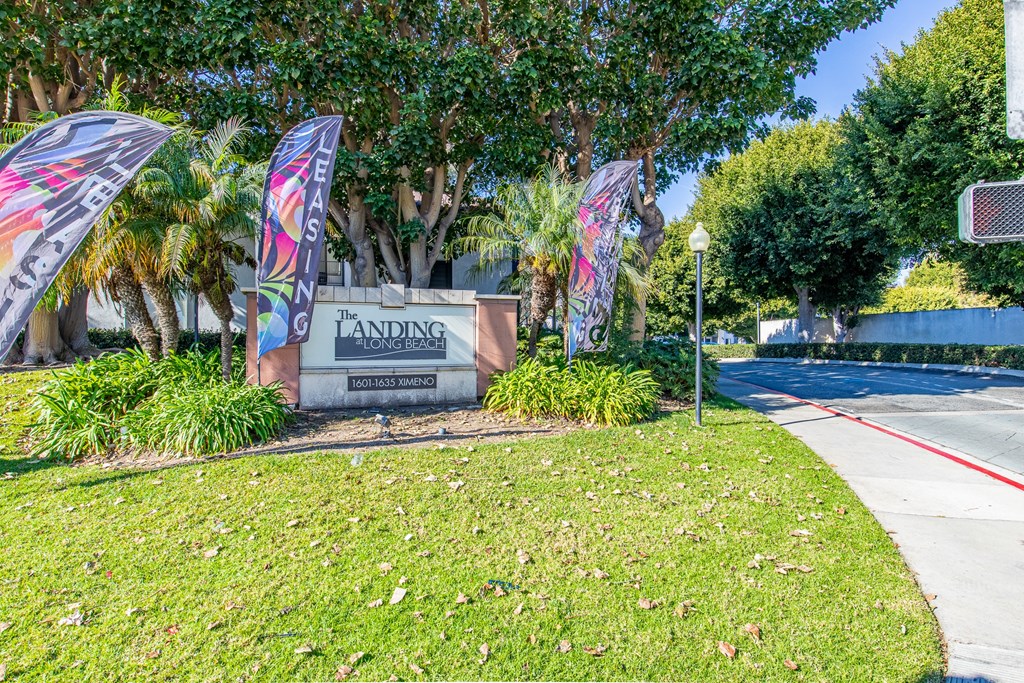 a sign for the harrison school district in front of a sidewalk and some flags