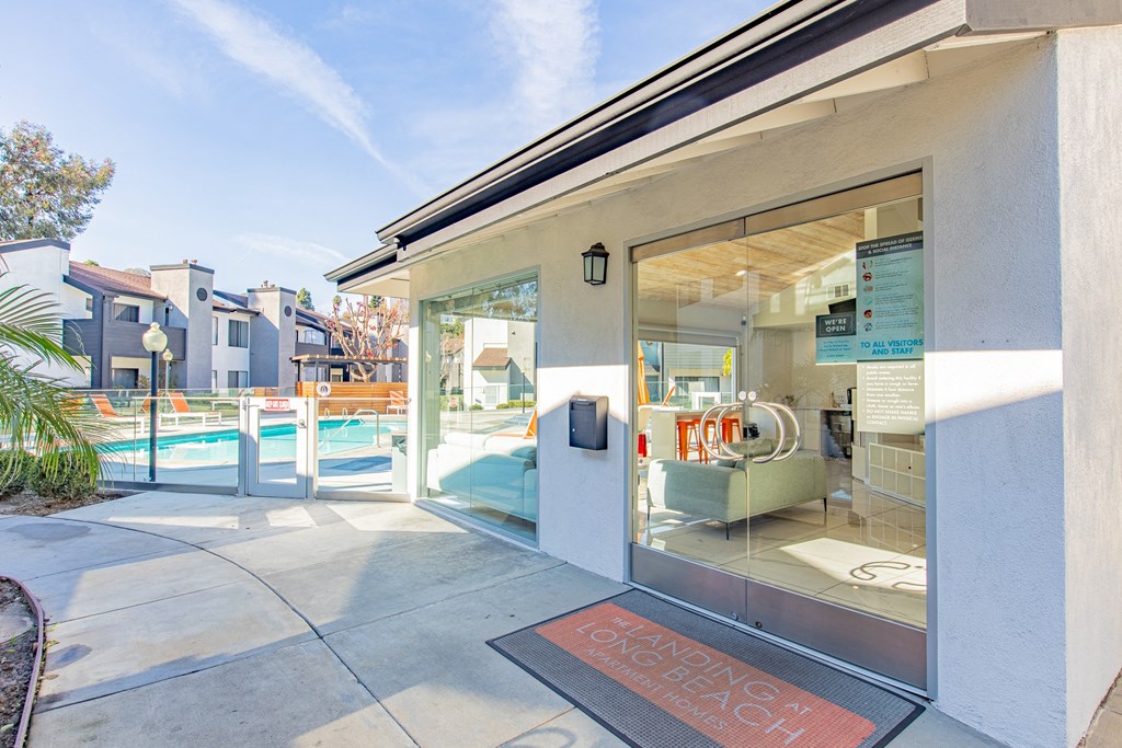 the entrance to a building with glass doors and a swimming pool