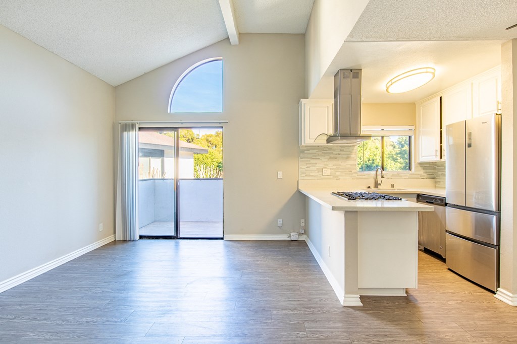 an empty kitchen with a stainless steel refrigerator and a sink