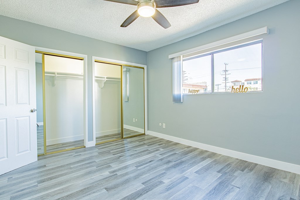 an empty room with a ceiling fan and a window
