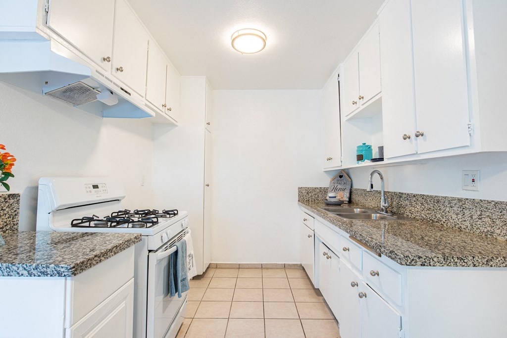 a kitchen with white appliances and granite counter tops