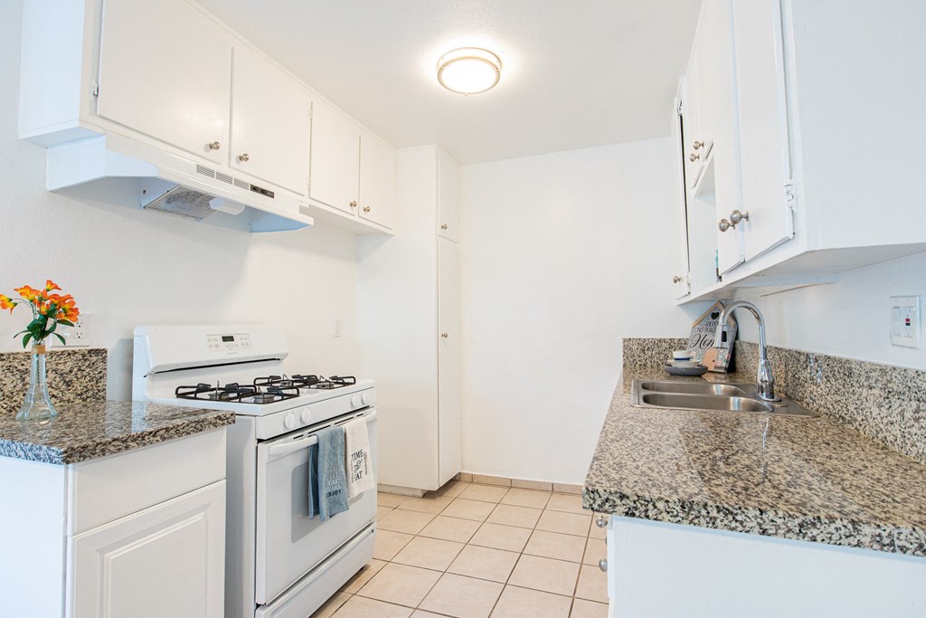 a kitchen with white appliances and granite counter tops