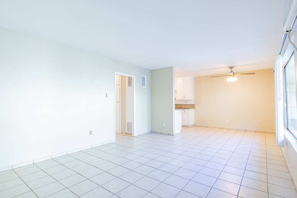 an empty living room with a tile floor