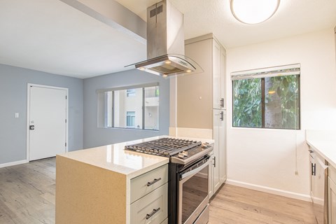 an empty kitchen with a stove and a window
