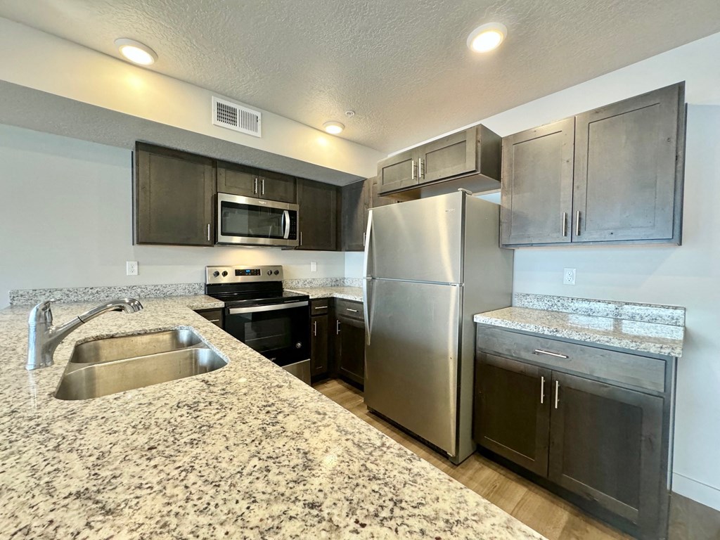 a kitchen with stainless steel appliances and granite counter tops