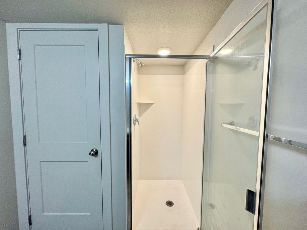 a small bathroom with a shower and a blue door
