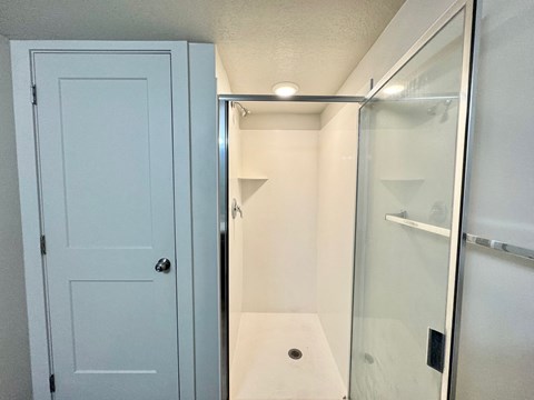 a small bathroom with a shower and a blue door