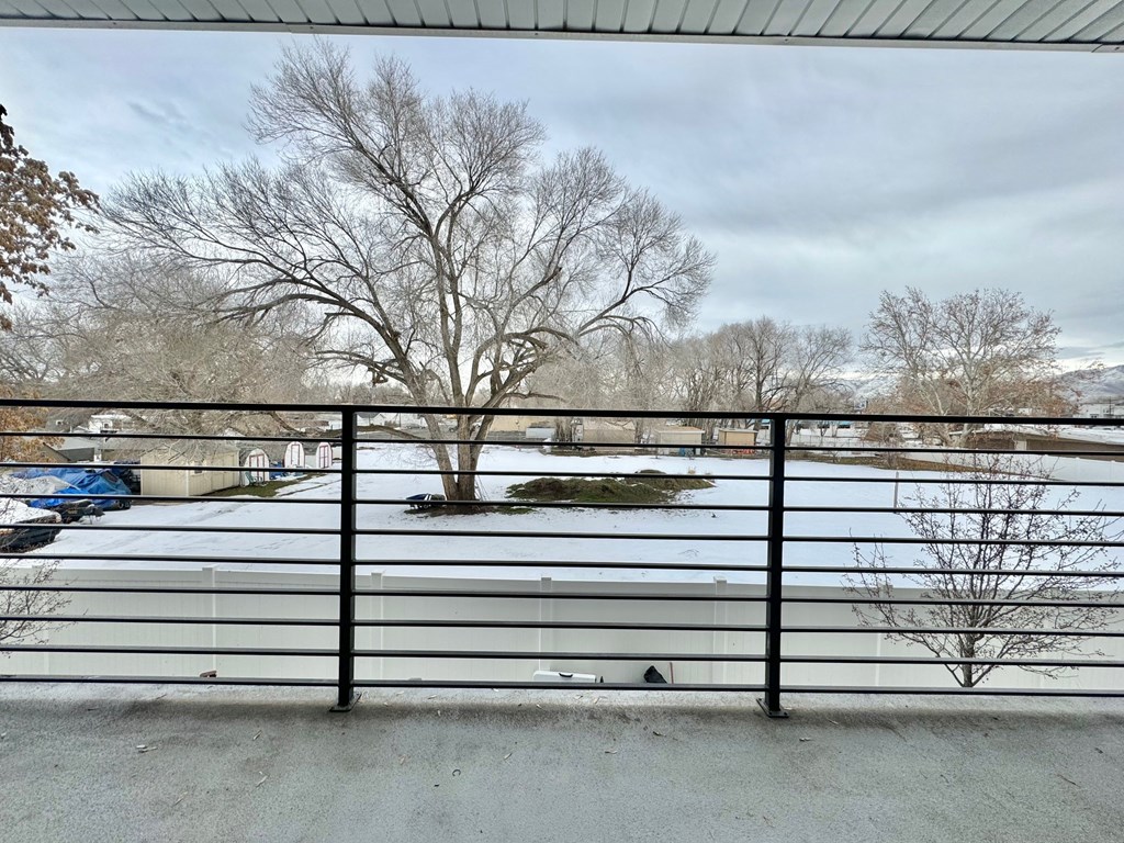 a view of a snow covered parking lot from behind a fence