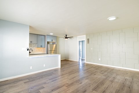 A kitchen with a white counter and a fan on the ceiling.