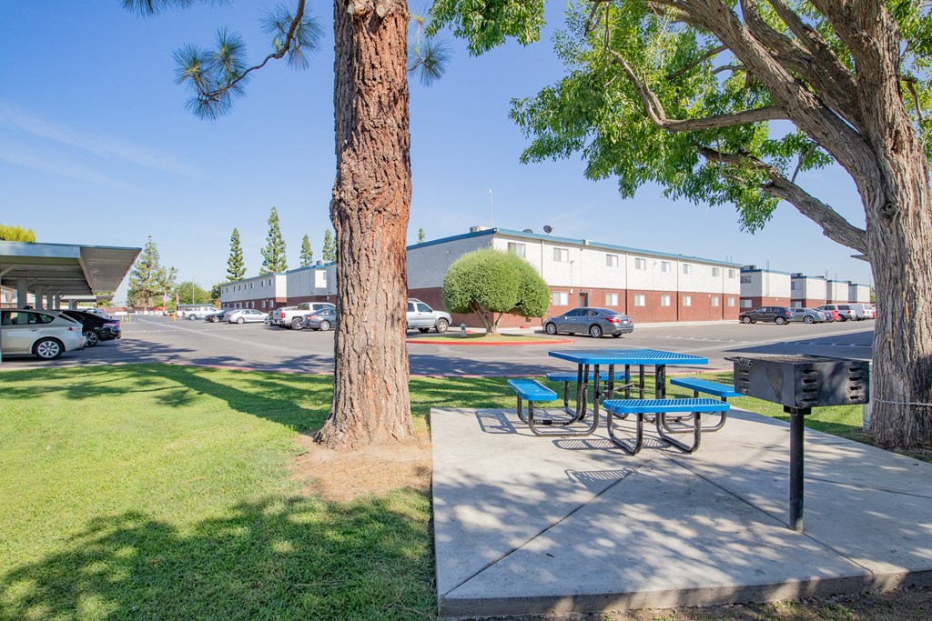 a picnic table on a sidewalk next to a parking lot