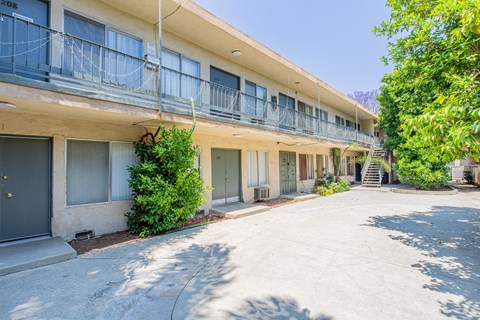 A sunny day at the apartment complex with balconies and trees.