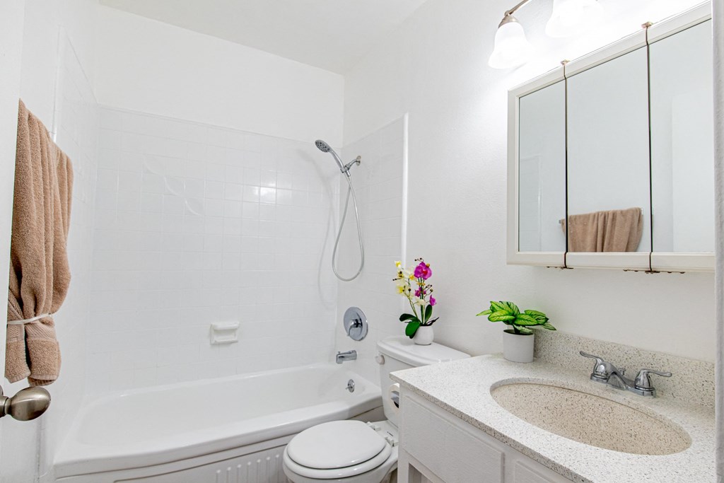 A white bathroom with a towel hanging on the wall.