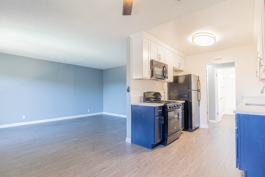 A kitchen with a black stove top oven and black refrigerator.