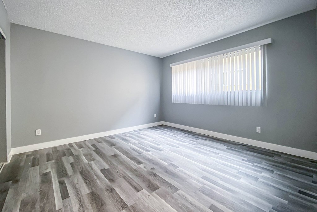 the living room of an empty house with wood flooring
